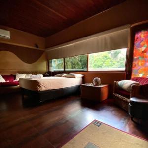 a bedroom with a large bed and a couch at Ololó Caracas B&B in Chacao