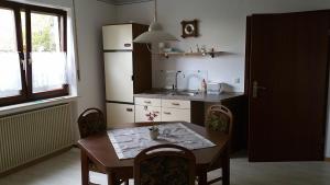 a kitchen with a table and a sink and a refrigerator at Kleine Wohnung am Radweg in Witzenhausen