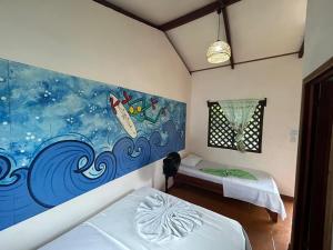 a room with two beds and a painting on the wall at Miss Miriam BeachFront Cabins in Tortuguero
