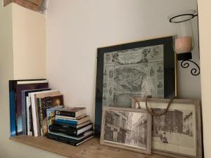 a shelf with books and photographs and a picture at Tiramisù in Tivoli