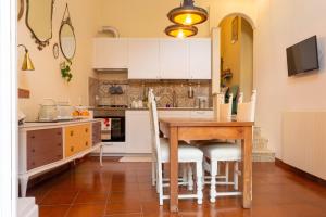 a kitchen with a wooden table and white cabinets at Tiramisù in Tivoli