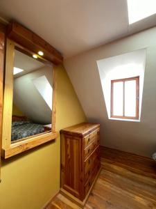 a bedroom with a mirror and a wooden dresser at Hostal Corvatsch Chile in San Pedro de Atacama