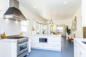 a kitchen with white cabinets and a stove at Little Italy 3BD Home with Huge Patio & Backyard in San Diego