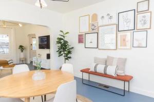 a dining room with a wooden table and white chairs at Little Italy 3BD Home with Huge Patio & Backyard in San Diego