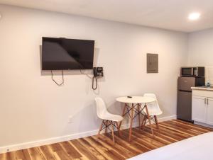 a room with a table and chairs and a tv on the wall at Vermont Suites in South Burlington +105 photos