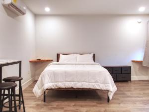 a white bedroom with a bed and two stools at Vermont Suites in South Burlington