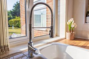 a kitchen sink with a faucet in front of a window at The Secret Garden - West Sussex - 3BR House with Drive in Crawley +32 photos