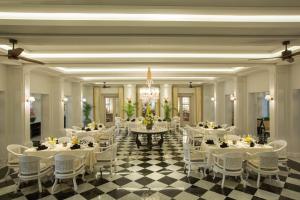 a banquet hall with white tables and white chairs at The Shalimar Boutique Hotel in Malang