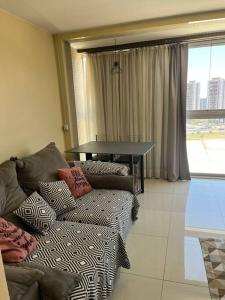 ein Wohnzimmer mit Sofa und Tisch in der Unterkunft Vista Encantadora - Flat DFPlaza Shopping in Águas Claras
