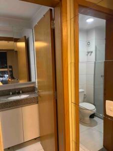 ein Badezimmer mit Toilette, Waschbecken und Spiegel in der Unterkunft Vista Encantadora - Flat DFPlaza Shopping in Águas Claras