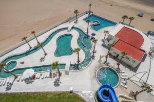 eine Draufsicht auf einen Swimmingpool neben einem Strand in der Unterkunft Encantame Towers 2 -Bedroom Luxury DLX Verano E905- Corner Balcony in Playa Encanto