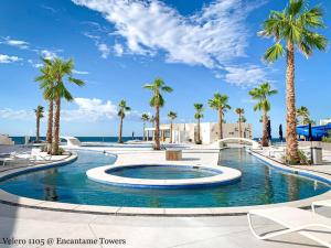 einen großen Pool mit Palmen in einem Resort in der Unterkunft Encantame Towers 2 -Bedroom Luxury DLX Verano E905- Corner Balcony in Playa Encanto