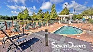 a swimming pool with lawn chairs at Villas at Seven Dwarfs Resort - Near to Disney in Kissimmee +41 photos