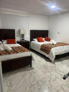 ein Schlafzimmer mit 2 Betten und ein Zimmer mit 2 Tischen in der Unterkunft Villa las Orquideas in La Loma