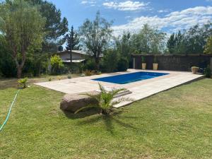 a swimming pool in a yard with a grass field at Alma de diamante in Cacheuta