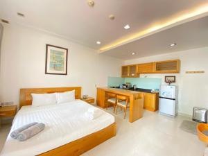 a bedroom with a bed and a kitchen at Qli Hotel Muine in Mui Ne