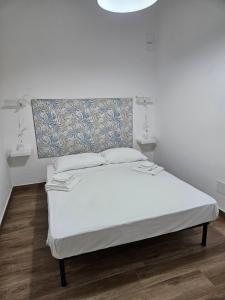 a bedroom with a white bed with a headboard at Onda Blu in Agropoli