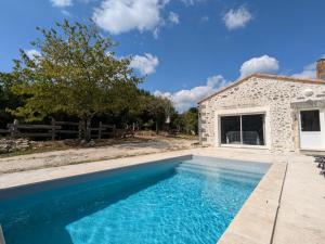 a swimming pool in front of a stone house at Maison familiale avec piscine privée et jardin pour 11 pers - FR-1-653-265 in Magnac-Lavalette