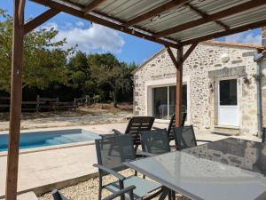 a patio with a table and chairs next to a pool at Maison familiale avec piscine privée et jardin pour 11 pers - FR-1-653-265 in Magnac-Lavalette