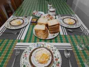 a table with plates of breakfast food on it at Green Villa in Nuwara Eliya