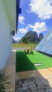 a view of a building with green grass and benches at Nour homestay Rumah B in Kaki Bukit +4 photos
