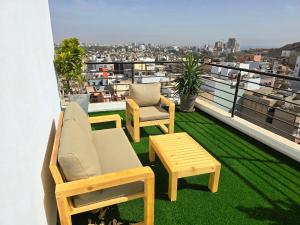 a balcony with two chairs and a table on a roof at Prestige Dakar in Ouakam