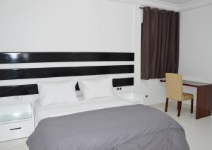 a bedroom with a bed and a desk and a chair at Prestige Dakar in Ouakam