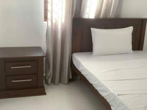 a bedroom with two beds and a nightstand and a bed sidx sidx sidx sidx at Ultra Modern 3 Bedroom Villa in Gampaha +12 photos