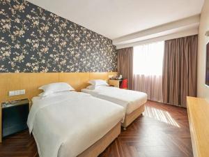 Ліжко або ліжка в номері Metropolo Hotel Jiangyin Hongqiao Road Baiye Plaza