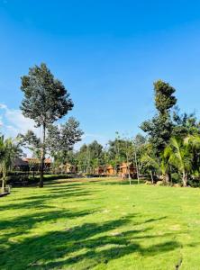 a green field with trees and houses in the background at Khu Nghỉ dưỡng Sinh thái Nhà Lụa Retreat in Ấp Quảng Giáo +20 photos
