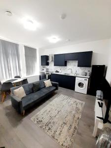 a living room with a couch and a kitchen at Modern 1 & 2 Bed Apartments, Desborough, Kettering, Sleeps 3, Free Parking, WIFI, Ideal for Families & Relocations in Kettering +22 photos