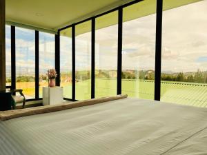 a bedroom with a bed and a large window at Hotel Club el Llano - Combita in Combita +39 photos