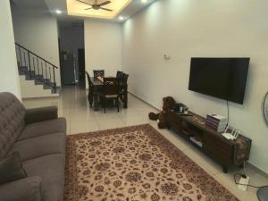 Una sala de estar con un sofá y un televisor de pantalla plana. en ROHMAH Homestay Sg Petani, en Kampong Baru 11 fotos más