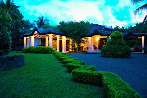 una casa con siepi di fronte a un cortile di Camellia Dwelling a Hikkaduwa Altre 37 foto