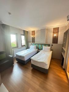two beds in a hotel room with wood floors at The Best City Kadikoy in Istanbul
