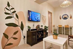 a living room with a tv on a wall at Boho Beach Vibes 2br Apt 2 in Makati in Manila
