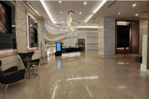 a lobby with chairs and a television in a building at Boho Beach Vibes 2br Apt 2 in Makati in Manila