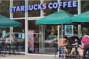 people sitting at tables in front of a starbucks coffee shop at Boho Beach Vibes 2br Apt 2 in Makati in Manila