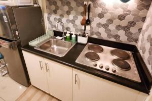 a small kitchen with a sink and a stove at Boho Beach Vibes 2br Apt 2 in Makati in Manila