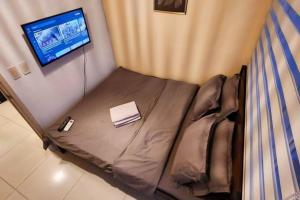 a small bed with a book on it in a room at Boho Beach Vibes 2br Apt 2 in Makati in Manila