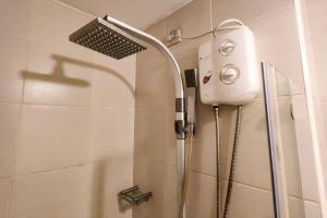a shower with a shower head in a bathroom at Boho Beach Vibes 2br Apt 2 in Makati in Manila