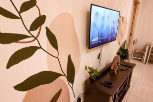 a living room with a flat screen tv on a wall at Boho Beach Vibes 2br Apt 2 in Makati in Manila