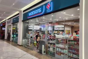 a person standing in front of a pharmacy store at Boho Beach Vibes 2br Apt 2 in Makati in Manila