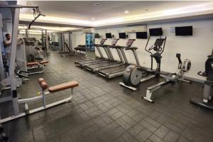 a gym with several treadmills and cardio machines at Boho Beach Vibes 2br Apt 2 in Makati in Manila