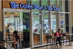 a coffee bean and tea leaf restaurant with people sitting outside at Boho Beach Vibes 2br Apt 2 in Makati in Manila