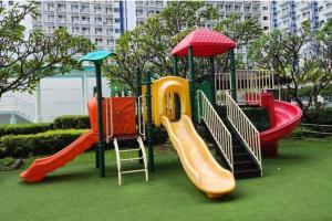 a playground with different colored slides on the grass at Boho Beach Vibes 2br Apt 2 in Makati in Manila