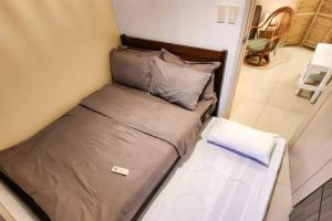 a small bed in a small room with at Boho Beach Vibes 2br Apt 2 in Makati in Manila