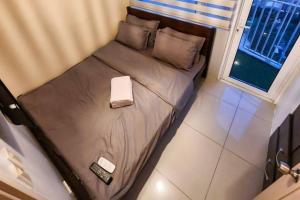 a small bed in a room with a window at Boho Beach Vibes 2br Apt 2 in Makati in Manila +27 photos