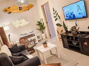 a living room with a couch and a flat screen tv at Boho Beach Vibes 2br Apt 2 in Makati in Manila