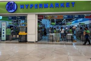 a supermarket with people standing outside of it at Boho Beach Vibes 2br Apt 2 in Makati in Manila